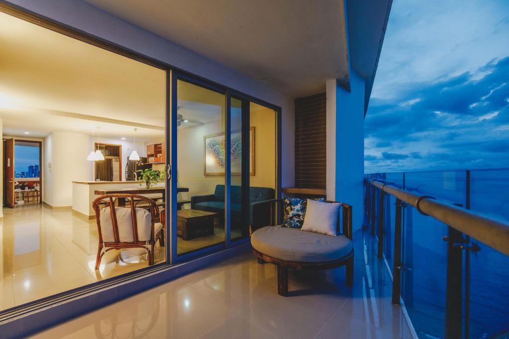 Zimmer mit einem Balkon mit einem Stuhl und einem Schlafzimmer. in der Unterkunft SkyMar Luxury 27 in Cartagena de Indias