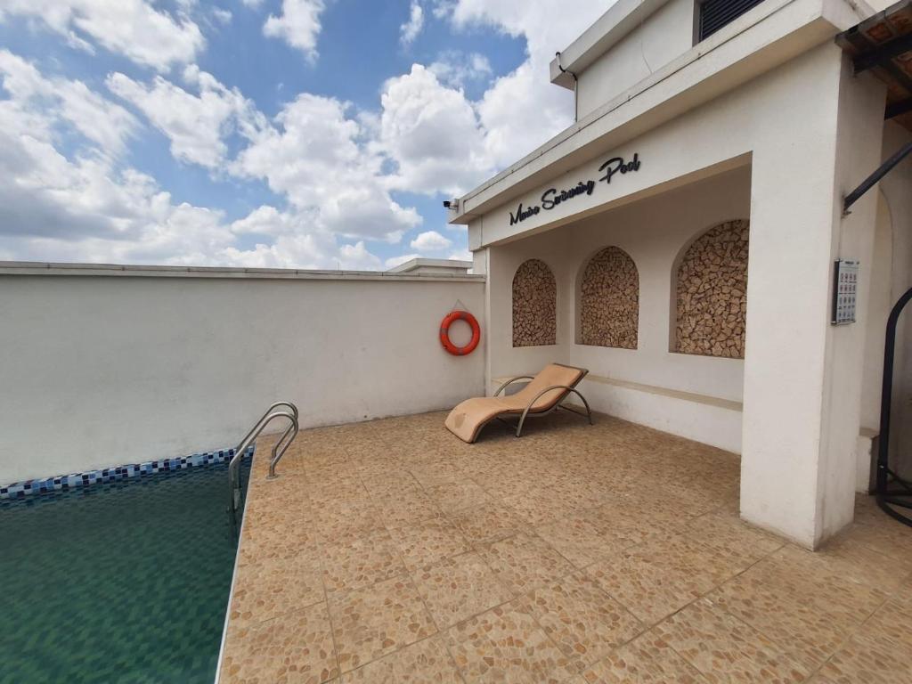 a patio with a chair next to a swimming pool at Cozy Apartment, 2 bedrooms, 2 bathrooms, Rooftop swimming, Full packed GYM, and workplaces in the Heart of Westlands, Nairobi in Nairobi