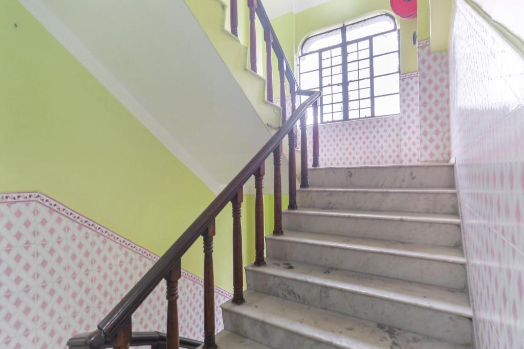 a staircase in a building with a window at Hotel O Bideshini Hotel in Tarapith