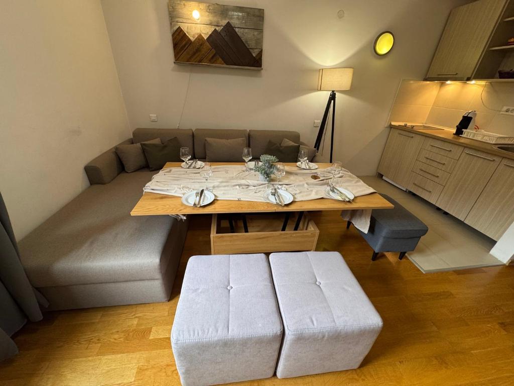 ein Wohnzimmer mit Tisch und Couch in der Unterkunft Apartment U345 - Aparthotel Vučko Jahorina - private host in Jahorina