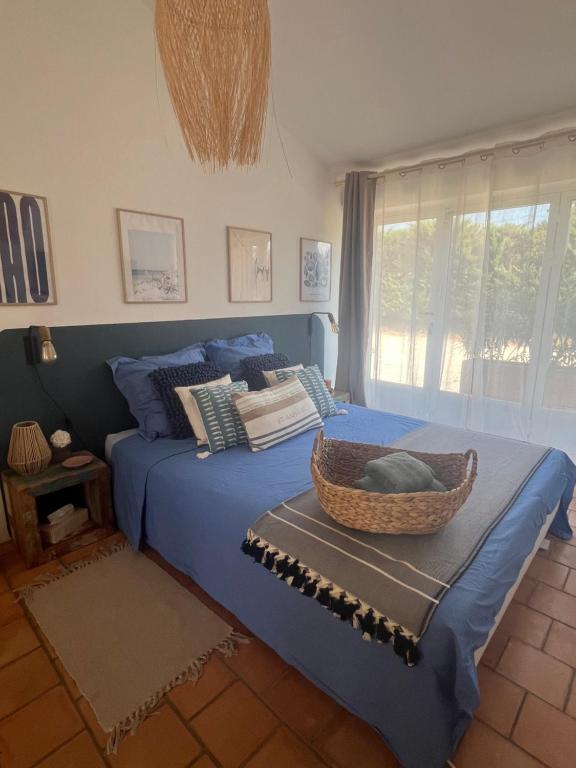 ein Schlafzimmer mit einem blauen Bett und einem Korb darauf in der Unterkunft Suite privée tout confort in Gargas