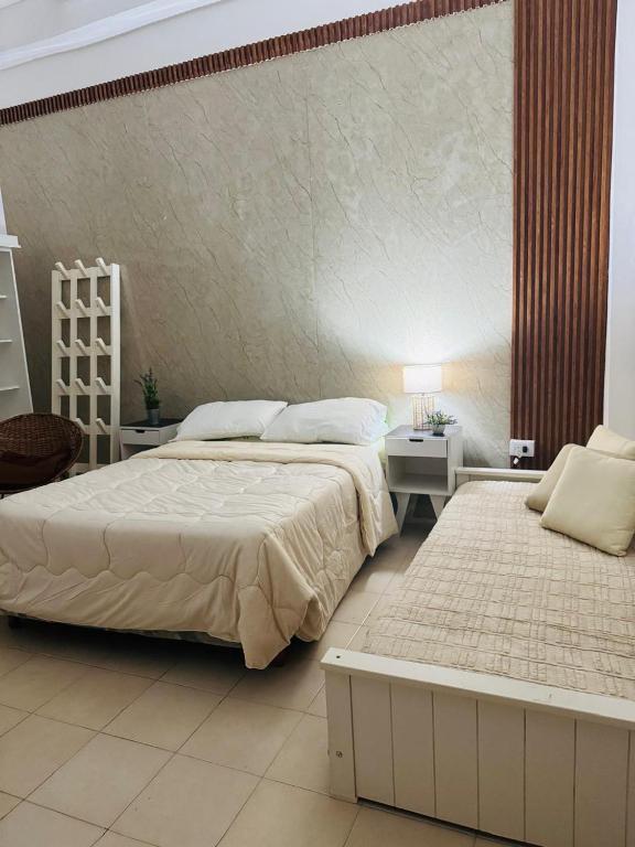 a bedroom with two beds and a table and a chair at Clorinda Departamentos in Clorinda