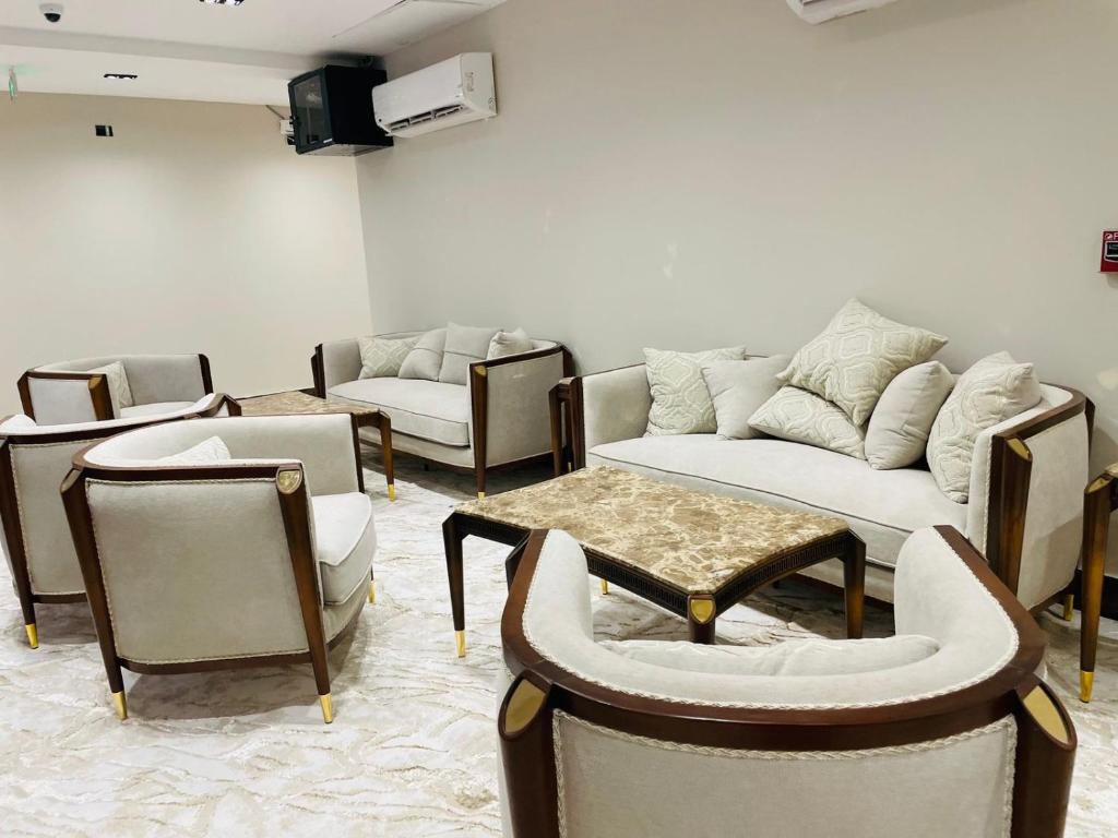 a living room with couches and chairs and a tv at desert rose hotel-فندق ديزرت روز in Siwa