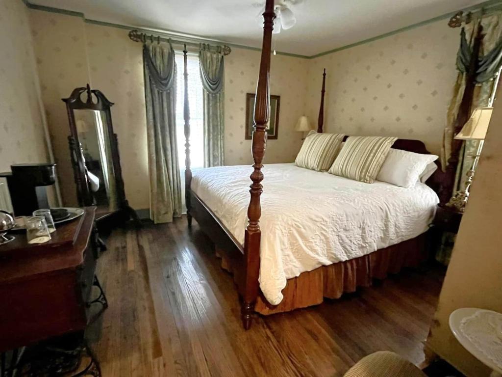 Schlafzimmer mit einem Bett und Holzboden in der Unterkunft Peddler's Pad in Jonesborough