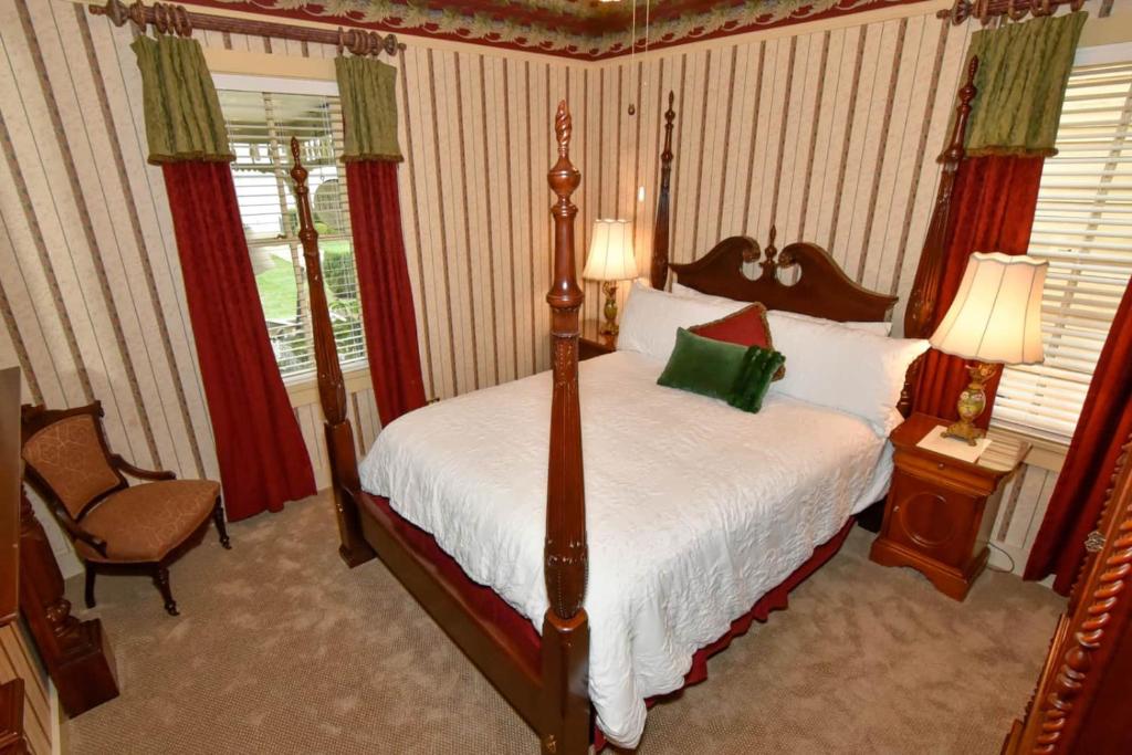 ein Schlafzimmer mit einem Bett, einem Stuhl und einem Fenster in der Unterkunft Peter Miller's Room in Jonesborough