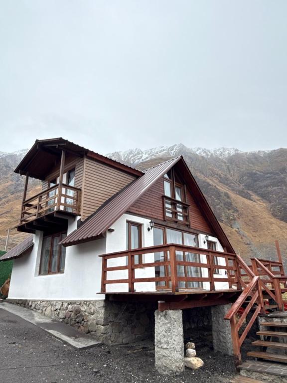 una casa con un balcón al costado en old white house, en Kazbegi