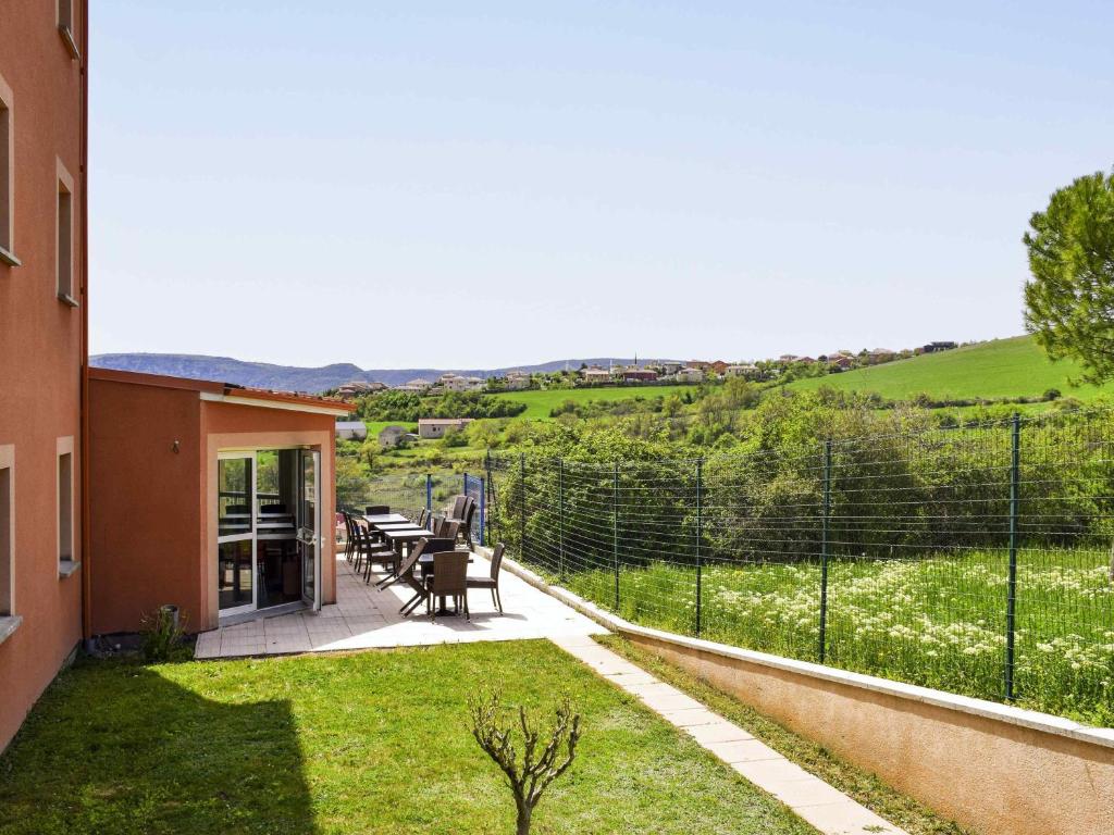 Aussicht von der Terrasse eines Hauses mit einem Tisch und Stühlen in der Unterkunft ibis Budget Millau Viaduc in Millau