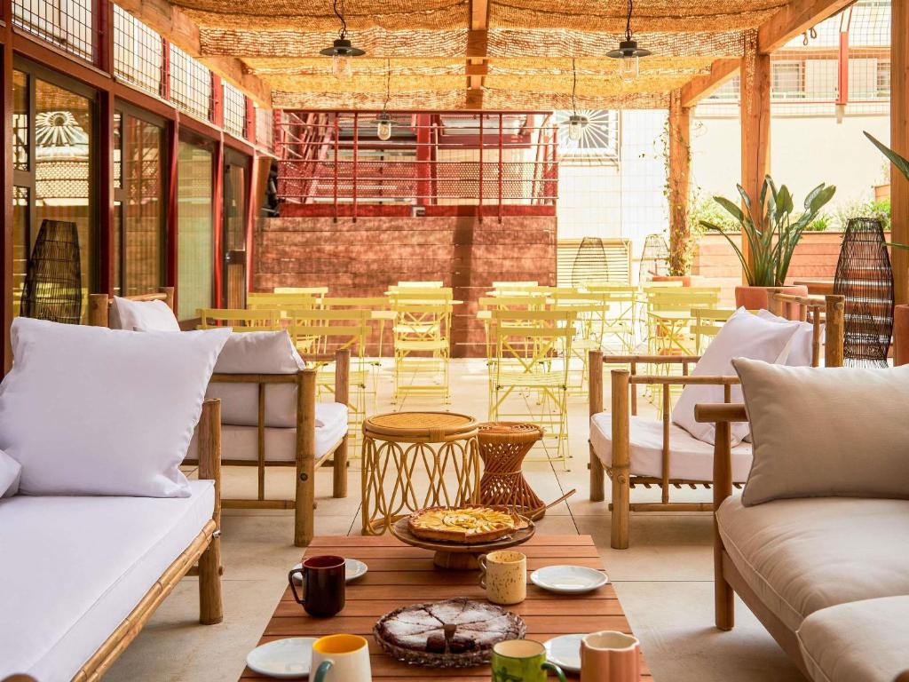 - un salon avec des canapés, des tables et des chaises dans l'établissement greet hotel Marseille Parc Chanot Velodrome, à Marseille