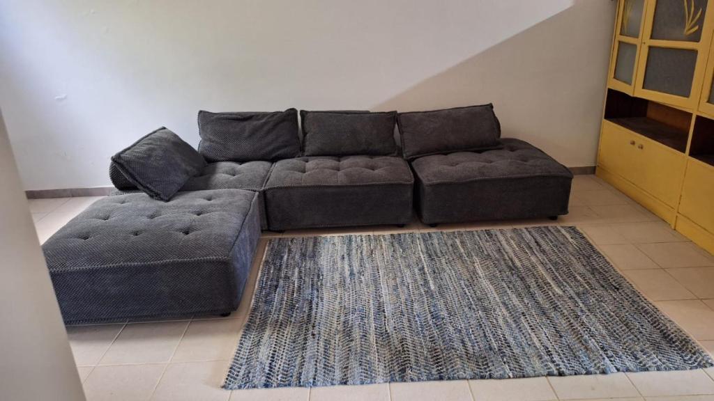 ein Wohnzimmer mit einer Couch und einem Teppich in der Unterkunft Kaza Manata in Praia