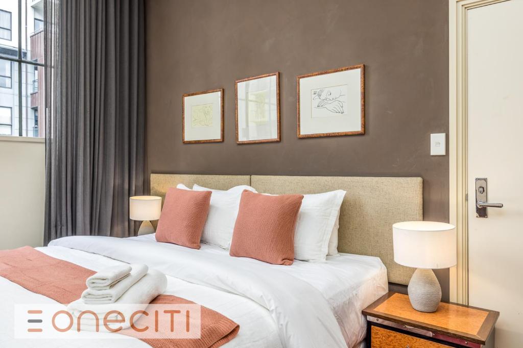 une chambre avec deux lits aux oreillers blancs et roses dans l'établissement Perfect City Pad in Heritage Complex, à Auckland