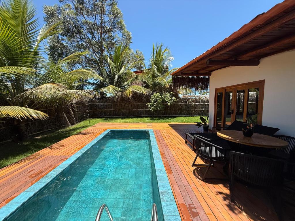 una piscina con una mesa junto a una casa en Corumbau Bangalôs, en Prado