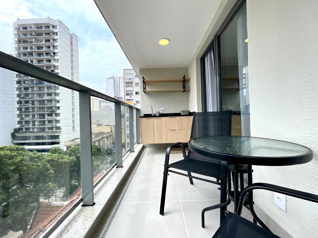 Un balcón con una mesa y vista a una ciudad. en Apart Hotel Praia Ingá Quarto, Sala, 2 Varandas e Vista Parcial MAC, en Niterói