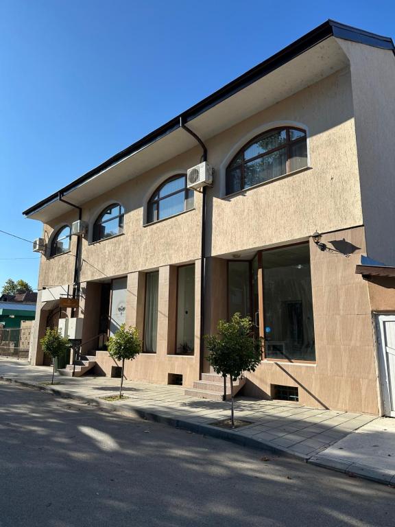 ein Gebäude an einer Straße mit Bäumen davor in der Unterkunft Georgia Suites in Lyubimets