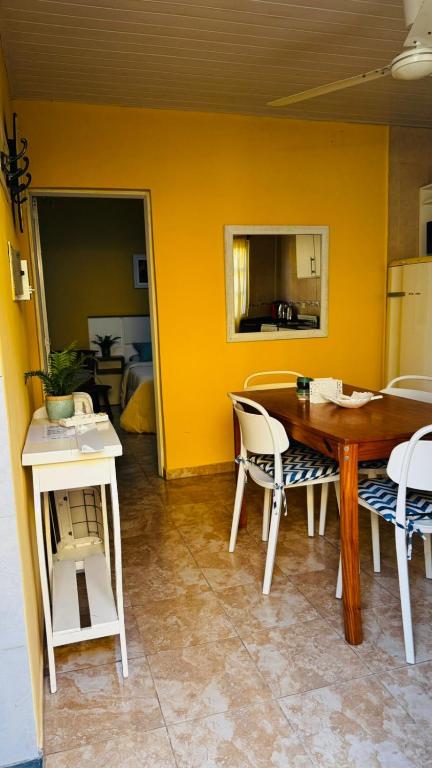 a table and chairs in a room with a yellow wall at Departamento Baba in Clorinda