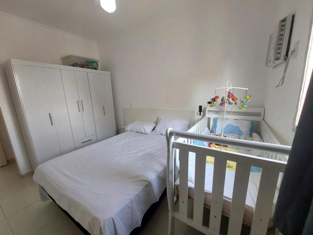 ein kleines Schlafzimmer mit einem Kinderbett und einem Bett in der Unterkunft Rê apdetemporadas em Olímpia 53 o melhor para sua Família Faça ja sua reserva in Olímpia