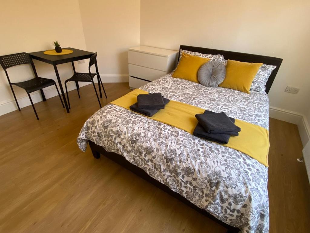 ein Schlafzimmer mit einem Bett und einem Tisch mit Stühlen in der Unterkunft 3 Beds house sleeps 5 Free Parking on drive London Romford PET friendly in Romford
