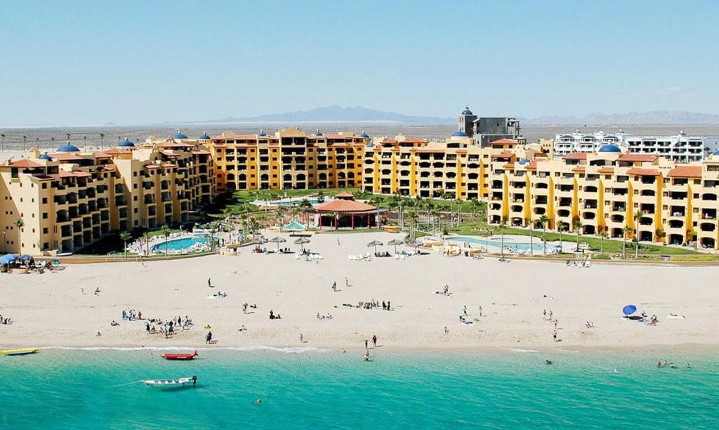 einen Strand mit einer Gruppe von Personen und Gebäuden in der Unterkunft Condo Heated Pool 2 Bed 2 Bath on Sandy Beach at Princesa in Puerto Peñasco