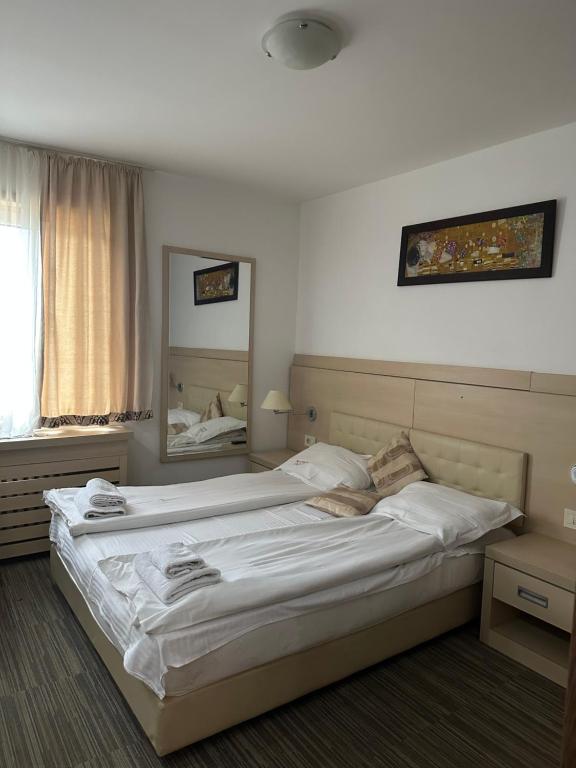 ein großes Bett in einem Schlafzimmer mit einem Spiegel in der Unterkunft Apartments Konaci Kopaonik in Kopaonik