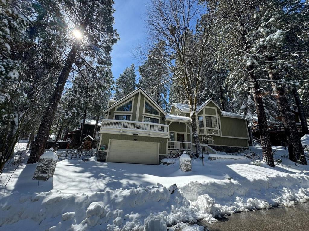 ein Haus mit Schnee und Bäumen in der Unterkunft Woodsy Chic Family-Friendly Spacious Getaway in Lake Arrowhead