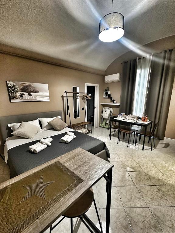 a bedroom with a bed and a table and chairs at Ma Maison Etnea in Catania