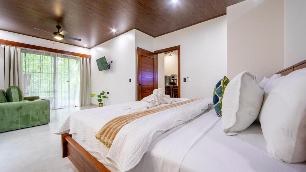 a bedroom with a large bed and a green couch at Villa Alma Verde in Fortuna