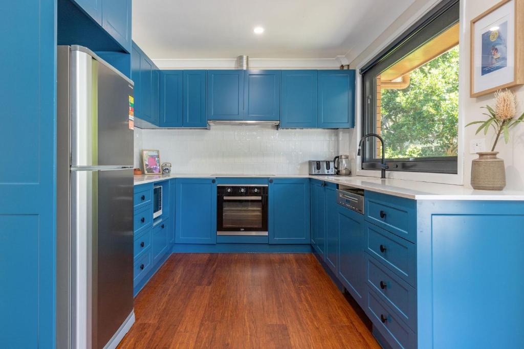 eine blaue Küche mit einer Spüle und einem Kühlschrank in der Unterkunft Barrels at Boomerang in Boomerang Beach