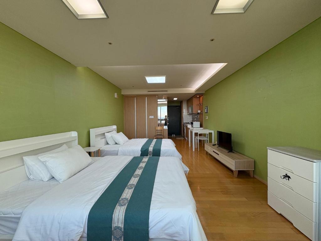 two beds in a room with green walls at 温馨小屋Cozy House in Incheon