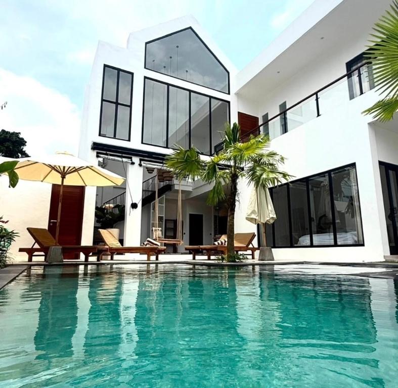 une maison avec une piscine devant une maison dans l'établissement Villa JAYA Nyanyi, à Munggu