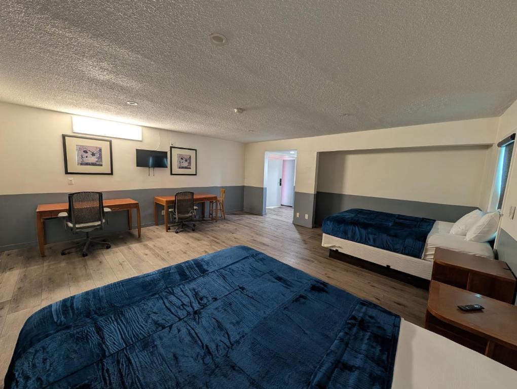 una camera da letto con un letto, una scrivania e un tavolo di Mirror Motel a Los Angeles