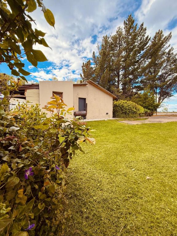 a house in a yard with a green lawn at Vientos del Lago - Tu refugio en la Patagonia in Los Antiguos