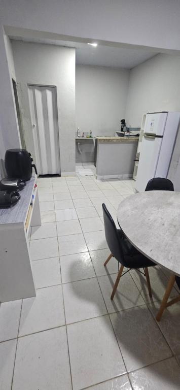 a kitchen with a table and chairs in a room at Quarto com otima localização in Manaus
