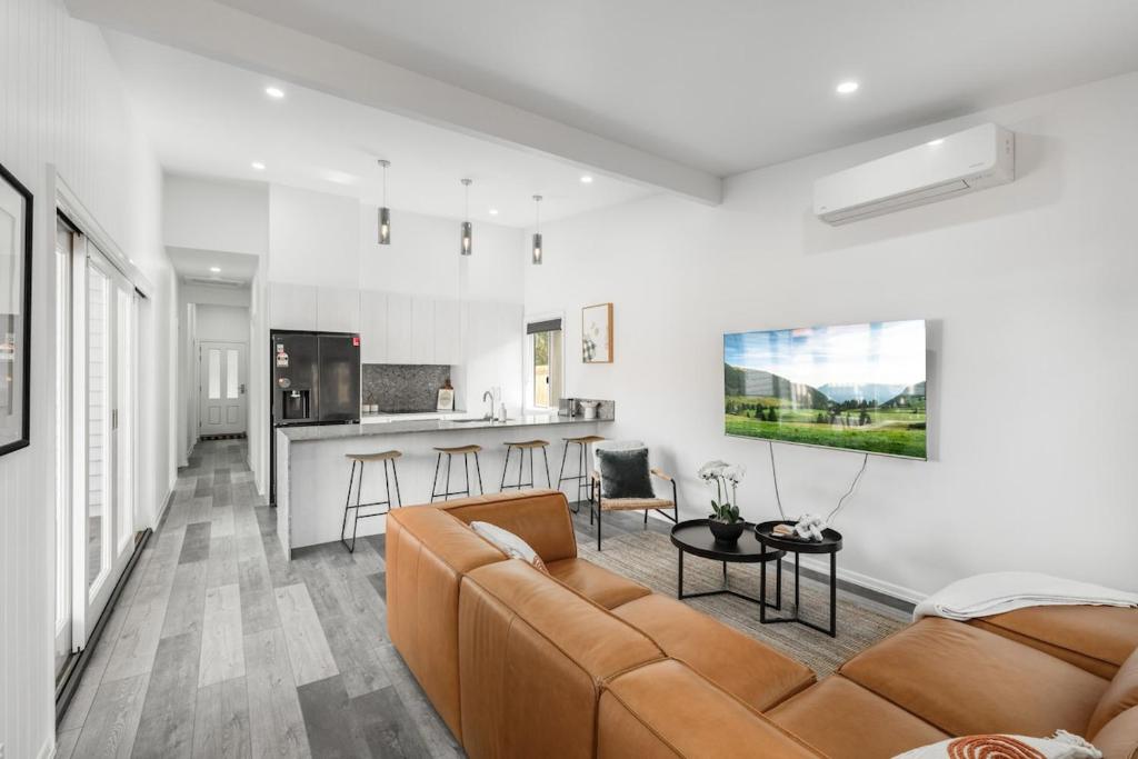 ein Wohnzimmer mit Couch und Küche in der Unterkunft Stylish Inner-City Stay! in Toowoomba