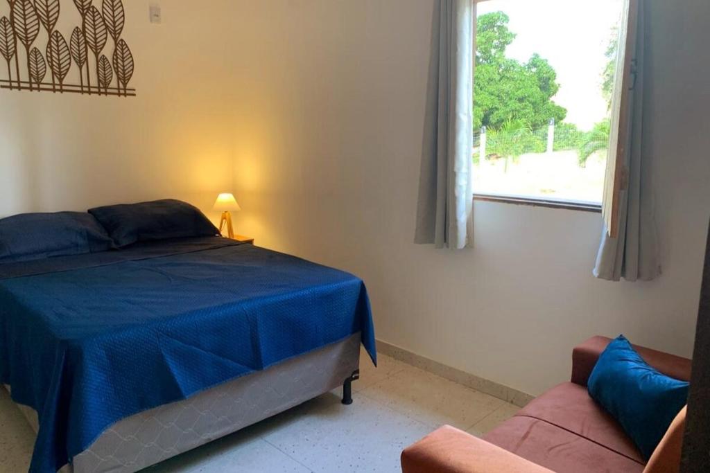 a bedroom with a bed and a window and a couch at CASA da CHi in Piranhas