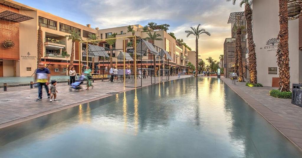 a group of people walking around a fountain in a mall at M Résidence Marrakech Luxury Serviced Apartments in Marrakesh