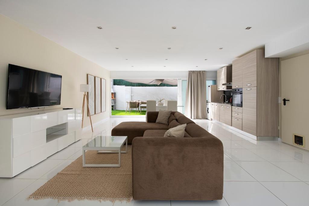 a living room with a couch and a tv at PLAYA a 3 minutos Parking barbacoa Apartamento en Castelldefels in Castelldefels