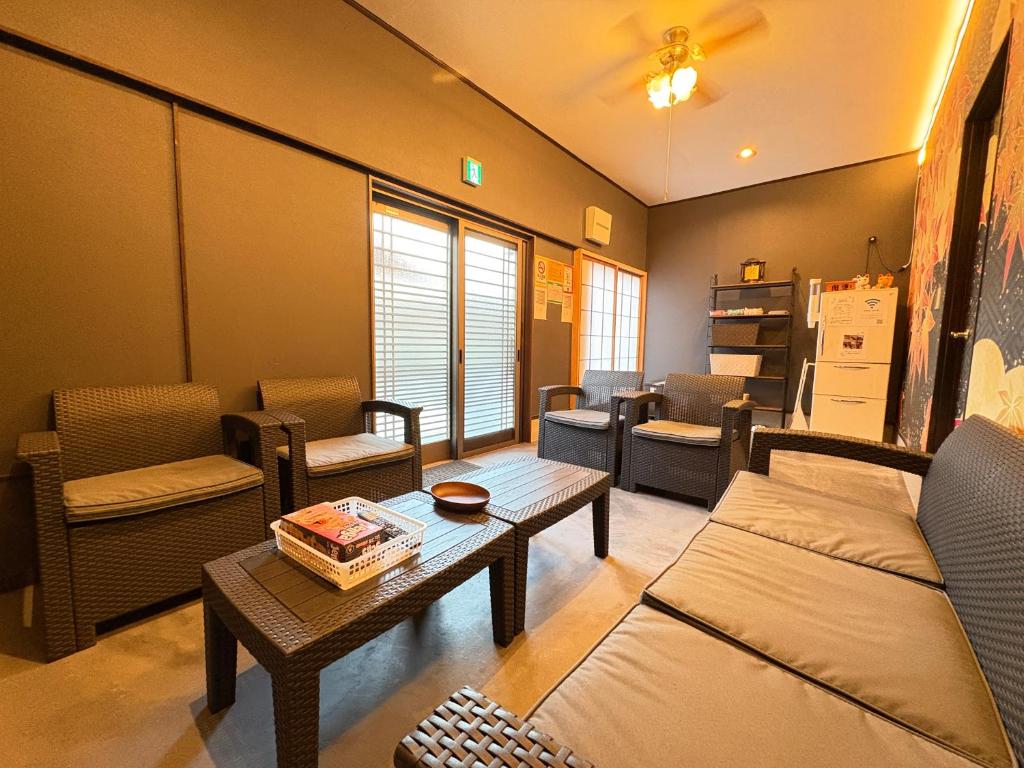 a living room with couches and a coffee table at Guesthouse すえ in Mashizume