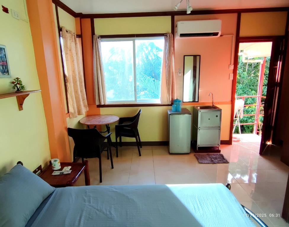 a bedroom with a bed and a table and chairs at Mango House Apartments in Panglao