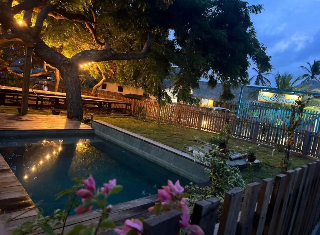 ein Swimmingpool in einem Hof mit einem Baum und einer Bank in der Unterkunft Casa Atina - Atins in Atins