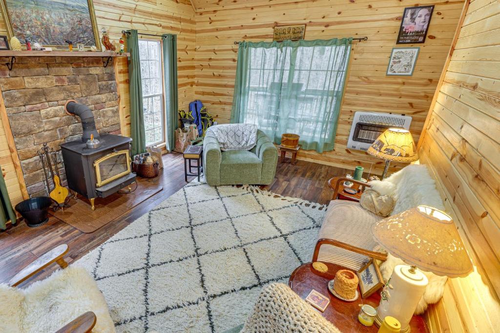 a living room with a fireplace in a log cabin at Greenbrier River On-Site! Modern-Rustic Log Cabin in Marlinton