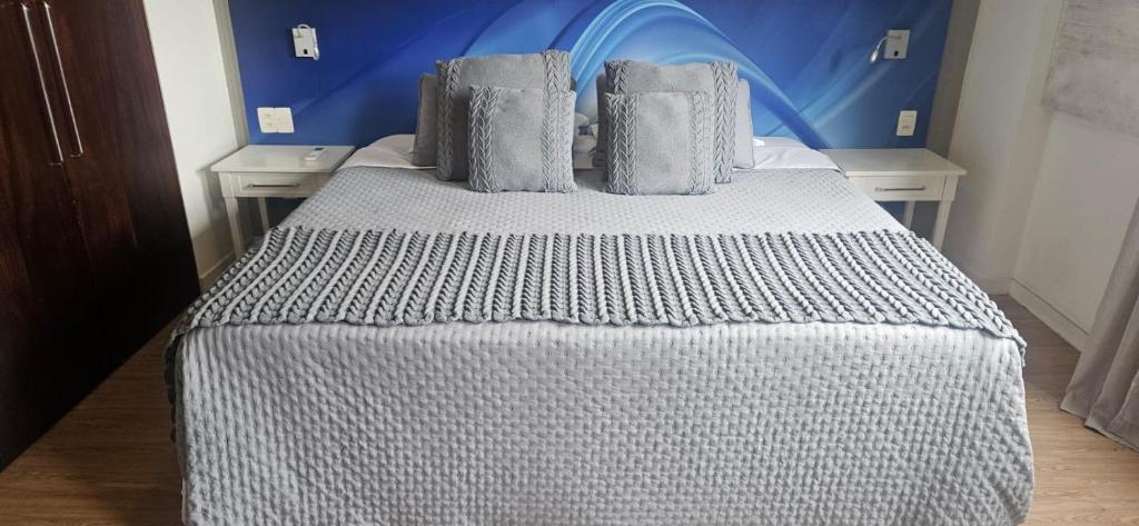 une chambre avec un lit avec un mur bleu dans l'établissement Prime Flat - Metrópolis Alphaville, à Barueri