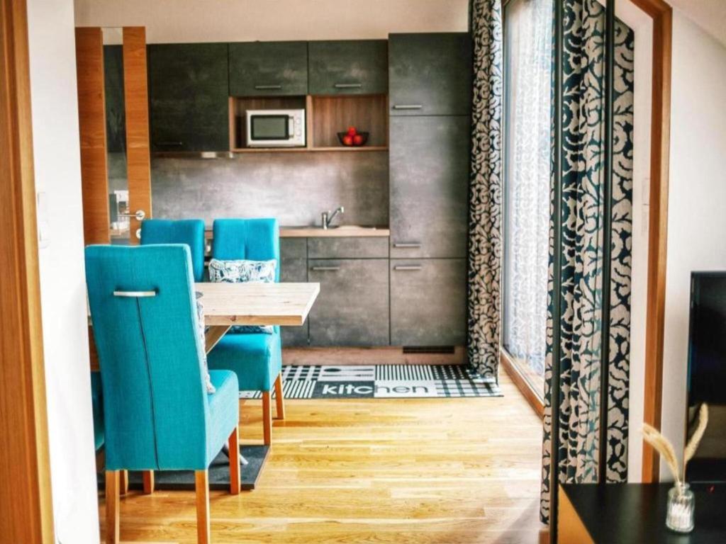 ein Esszimmer mit einem Tisch und blauen Stühlen in der Unterkunft Bösenstein in Hohentauern