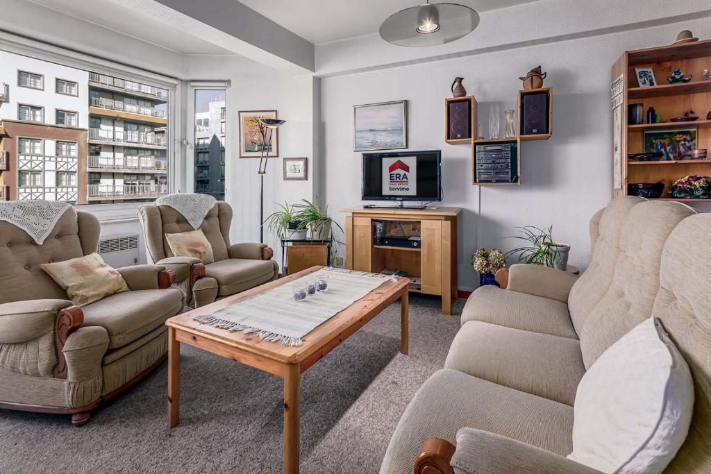 Una sala de estar con sofás y una mesa de café. en Duinedel 2A-2E, en Oostduinkerke