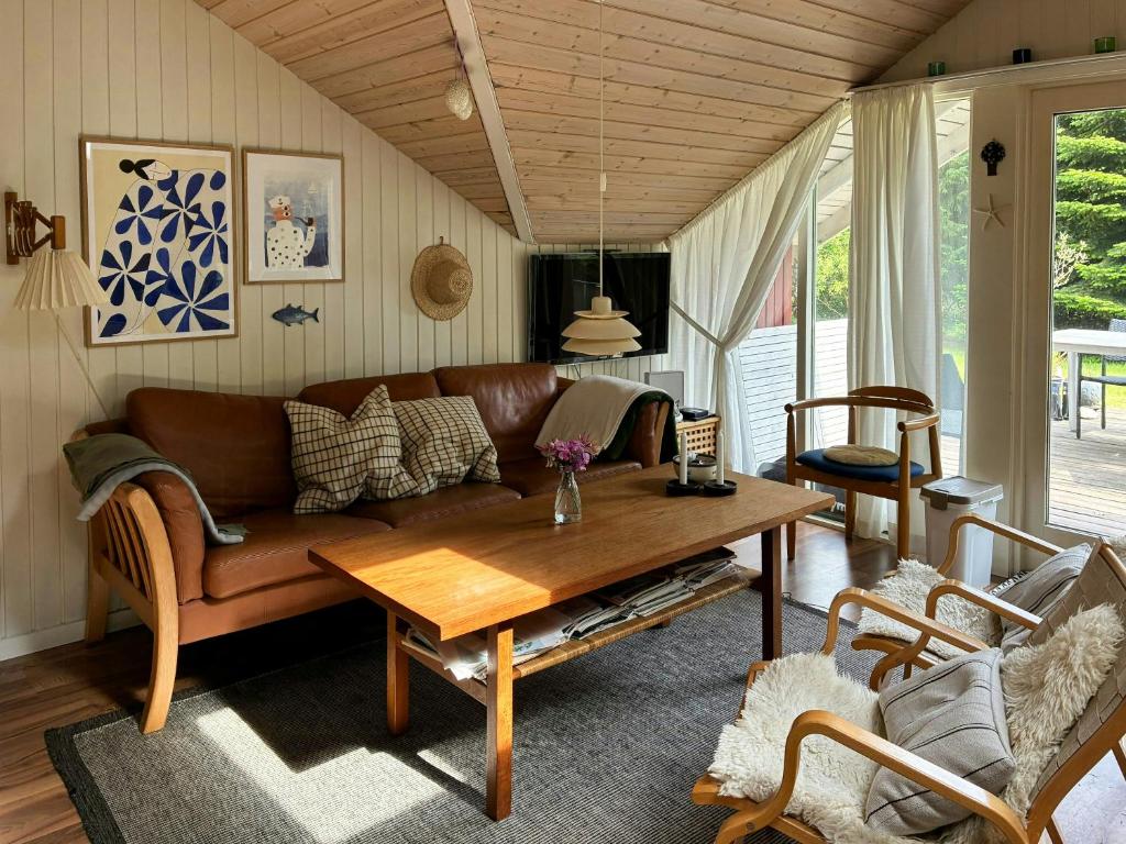 uma sala de estar com um sofá e uma mesa em Family Cabin By The Calm Waters Of Limfjord em Højslev