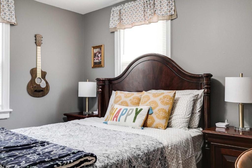 a bedroom with a bed with a guitar on the wall at The Cozy Bungalow 3 parking fully fenced yard in Sweet Briar Park