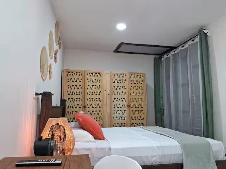 ein Schlafzimmer mit einem Bett mit einem Tisch und einem Tisch mit einem sidx sidx sidx sidx in der Unterkunft Habitaciones Smith in San José