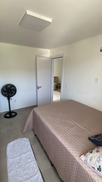a bedroom with a bed and a door to a room at Ap sol nascente in Itapema