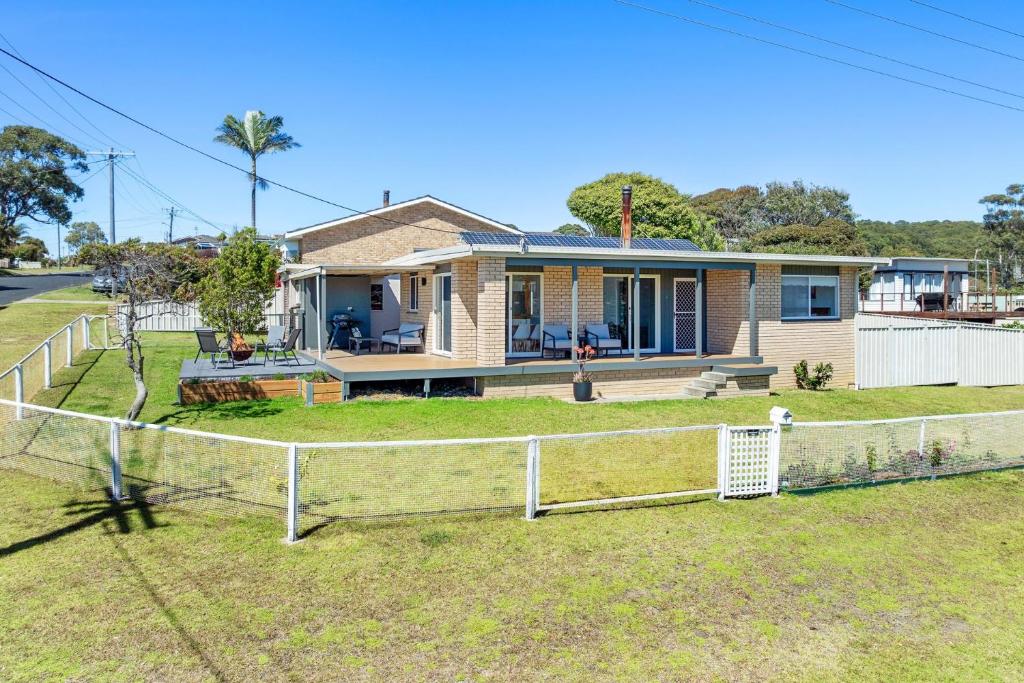 a house with a fence in front of it at Kianga Lodge, 1 Sunset Blvd in Kianga