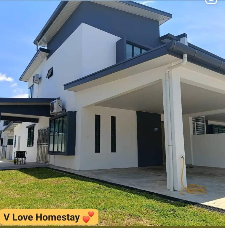 a large white house with a garage at V Love Homestay in Kota Samarahan