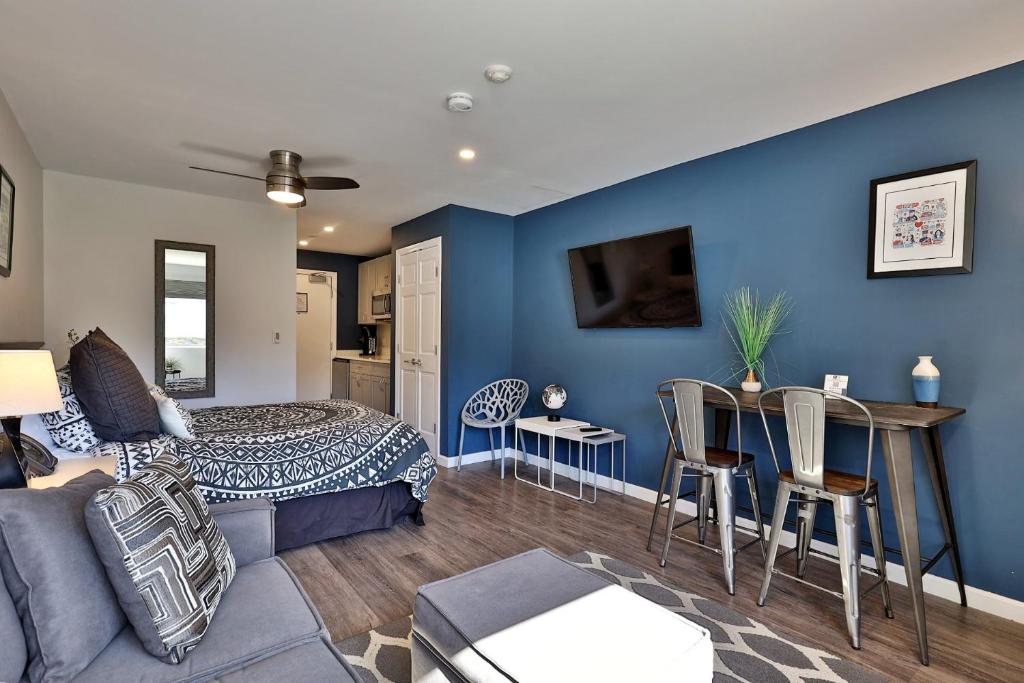 a bedroom with blue walls and a bed and a table at Killington Center Renovated Studio with Kitchenette on Bus Route and Discounted Ski Rentals in The Woods