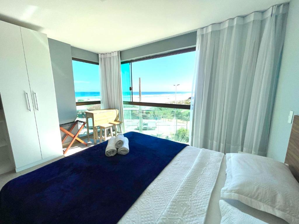 une chambre avec un lit et une vue sur l'océan dans l'établissement Eu Amo Arraial Hospedagem - Studio Sophia I Vista Mar, à Arraial do Cabo